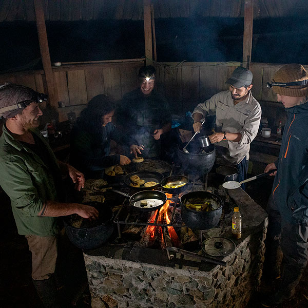 Image of a group of biologists cooking at a campsite